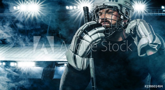 Picture of Ice Hockey player in the helmet and gloves on stadium with stick